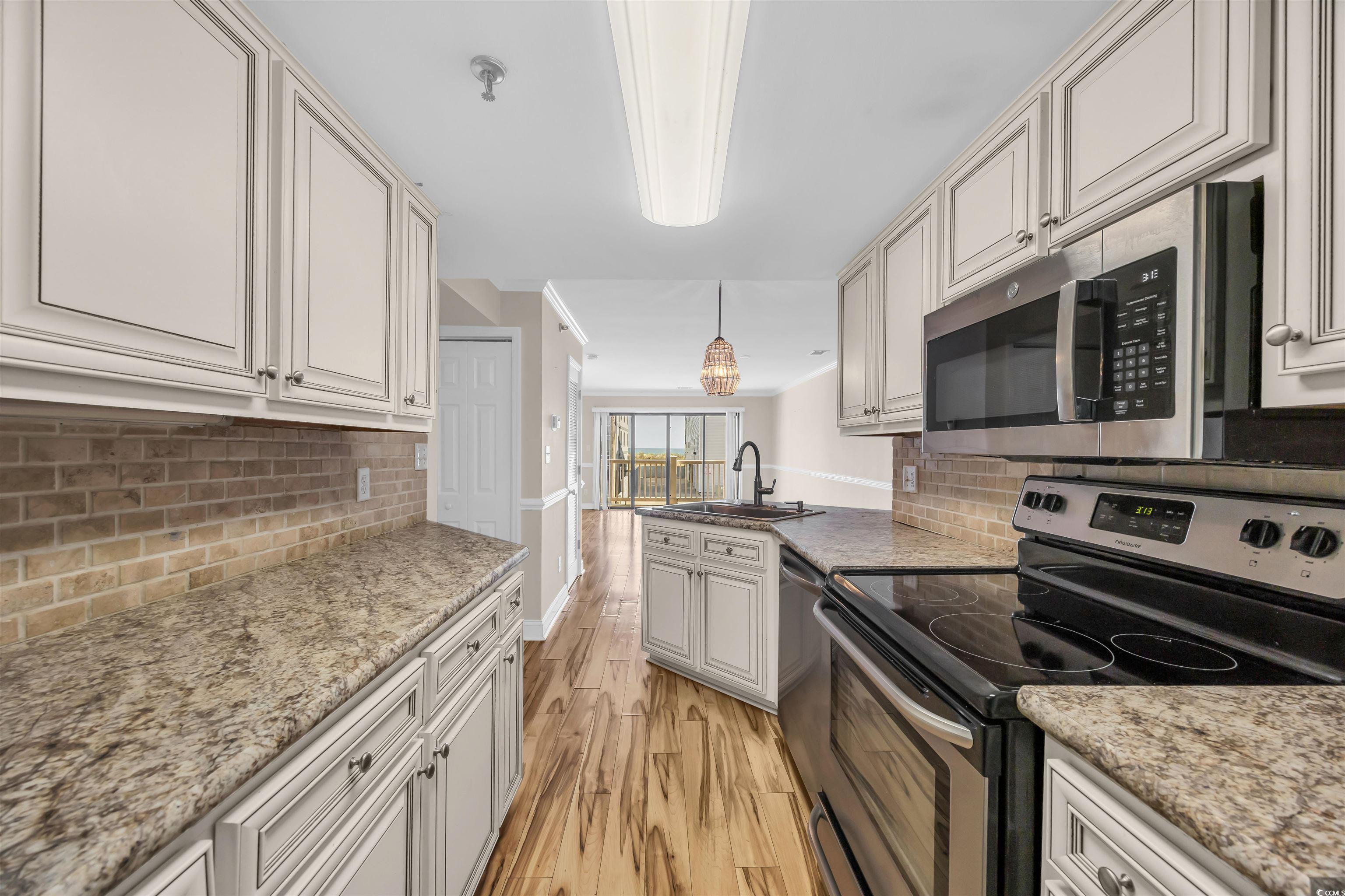 Image 4: Kitchen with light wood finished floors, a peninsu Image 4: Kitchen with light wood finished floors, a peninsu