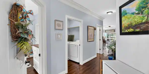 Image 3: Corridor with crown molding, dark wood-style floor