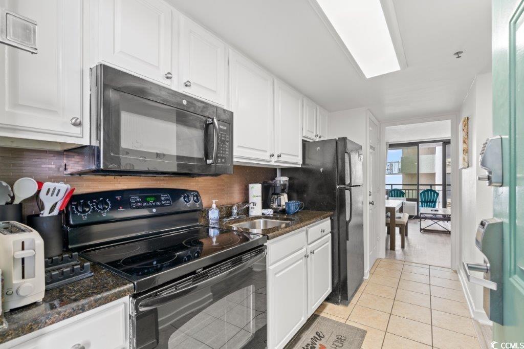 Image 3: Kitchen with brown cabinets, light tile patterned