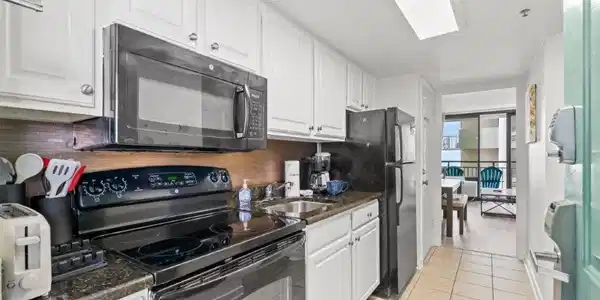 Image 3: Kitchen with brown cabinets, light tile patterned Image 3: Kitchen with brown cabinets, light tile patterned