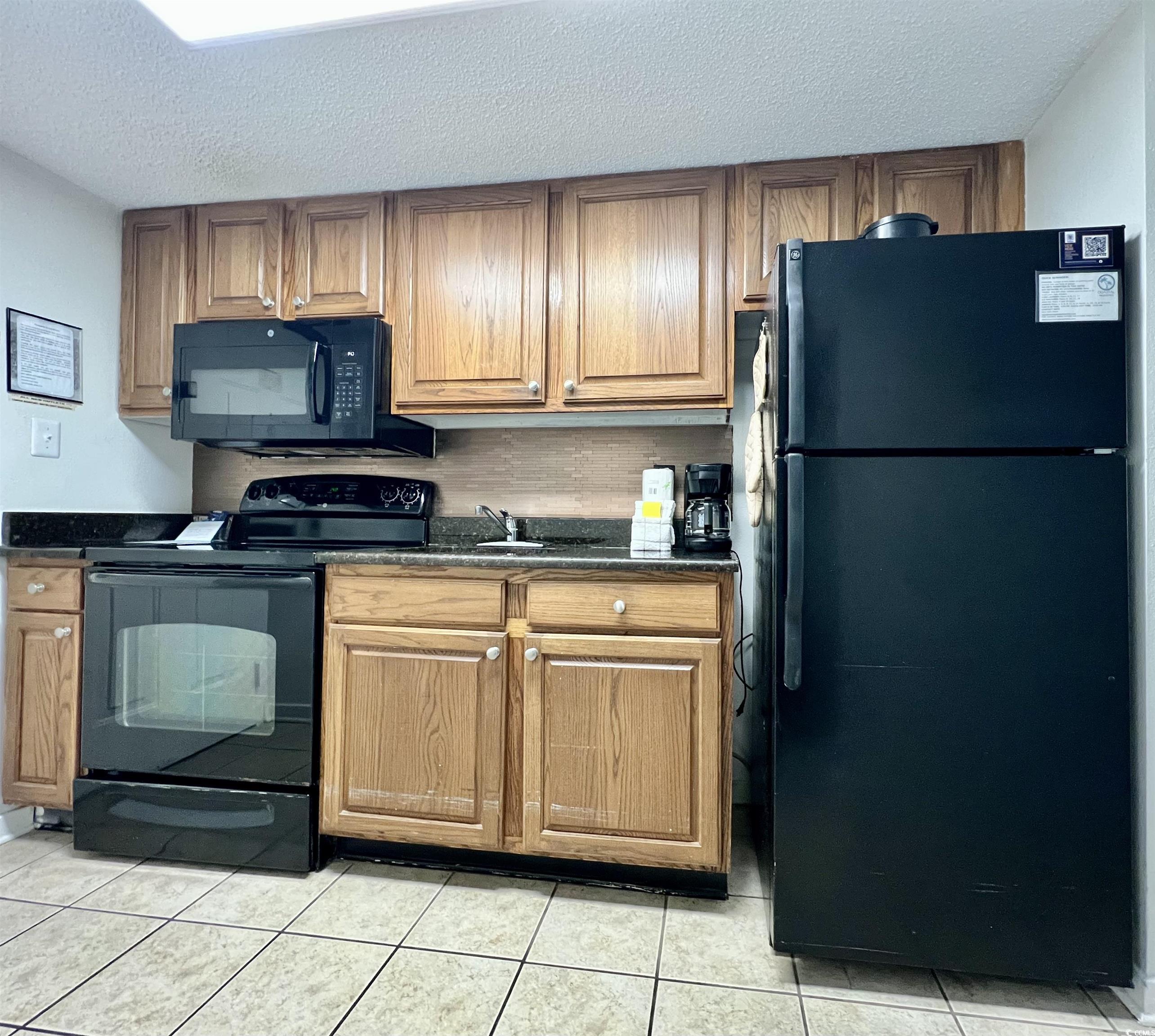 Image 4: Kitchen with dark countertops, black appliances, l