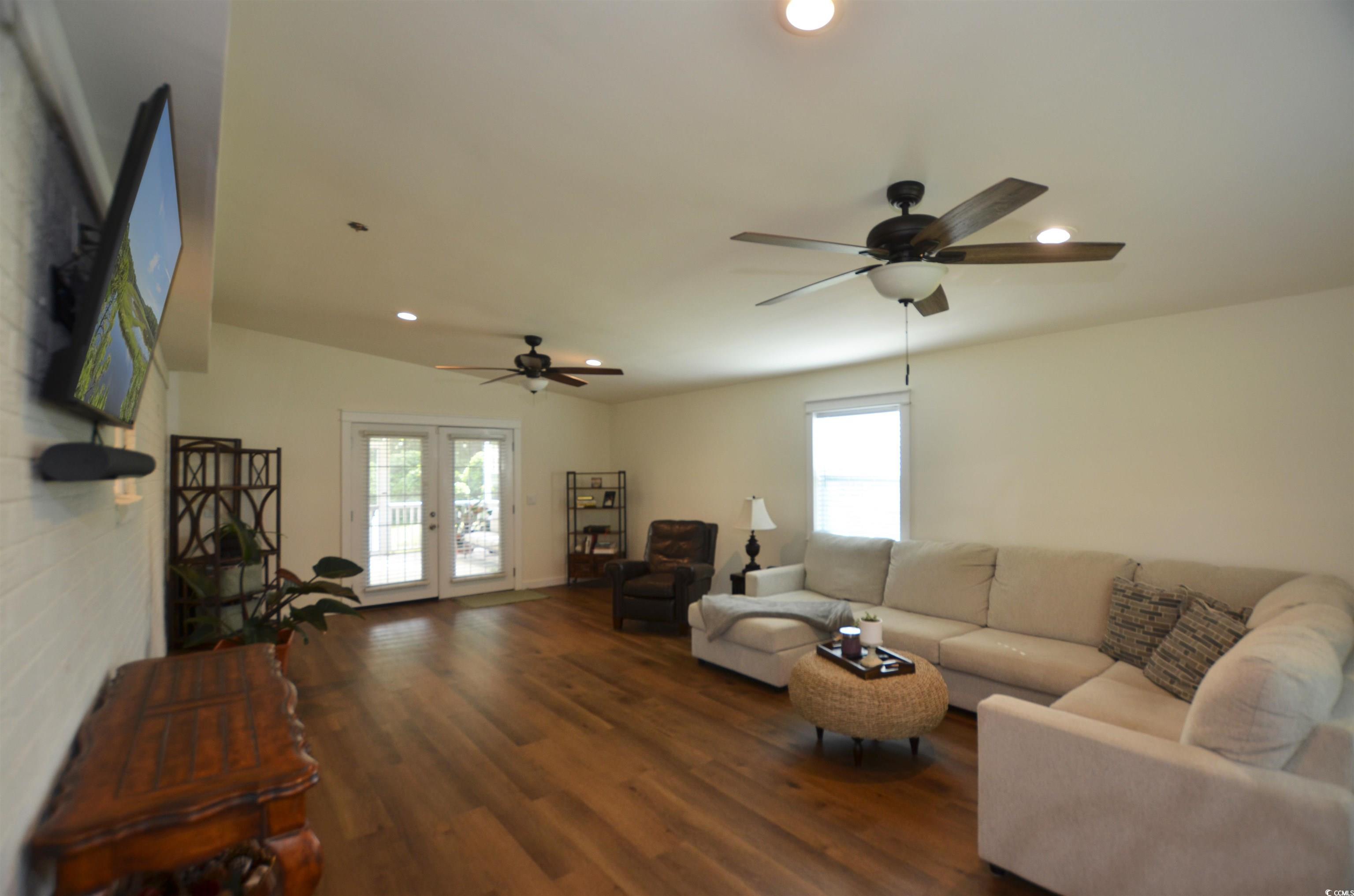 Image 4: Living area with a ceiling fan, wood finished floo
