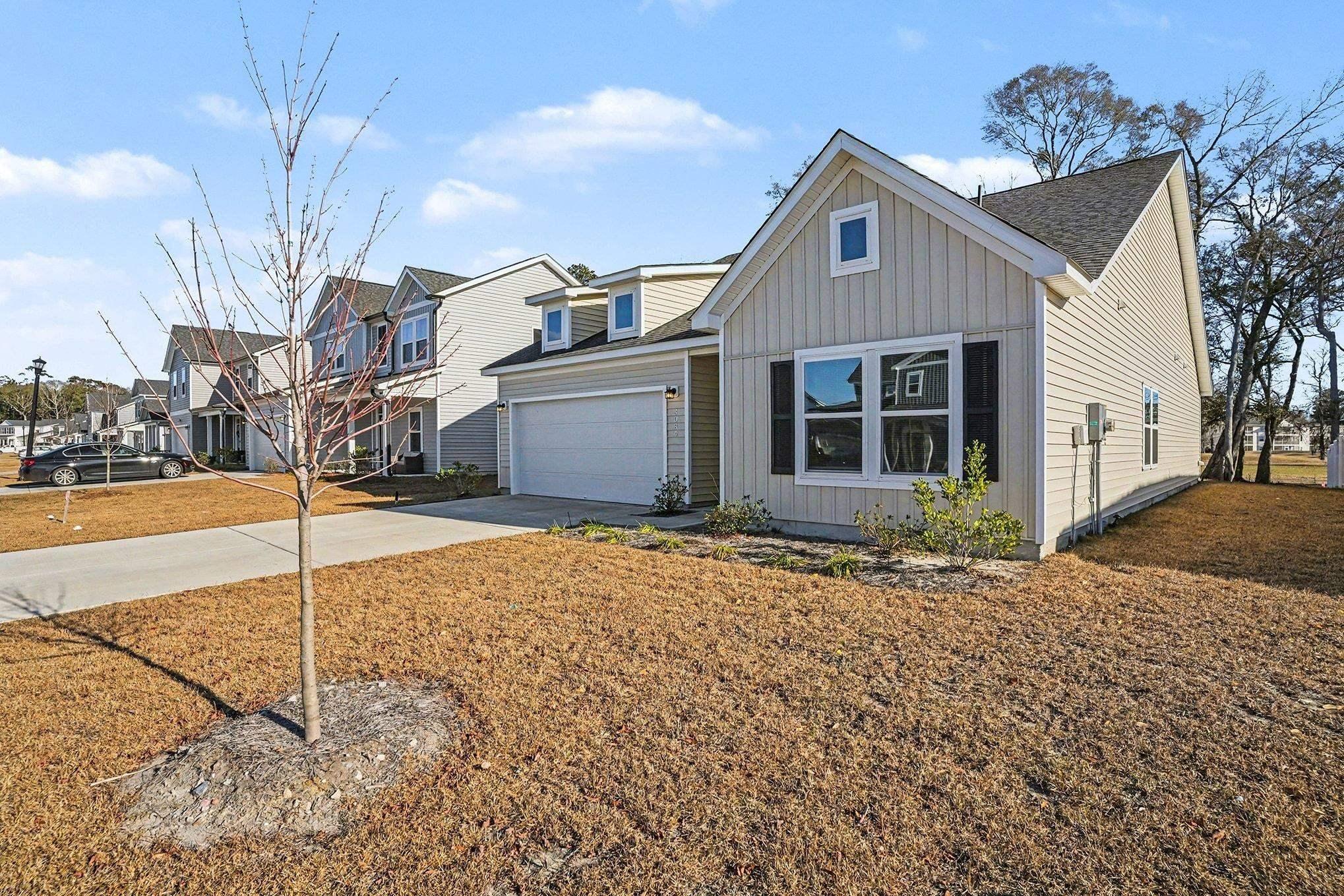 Image 4: View of front of home with concrete driveway, boar Image 4: View of front of home with concrete driveway, boar