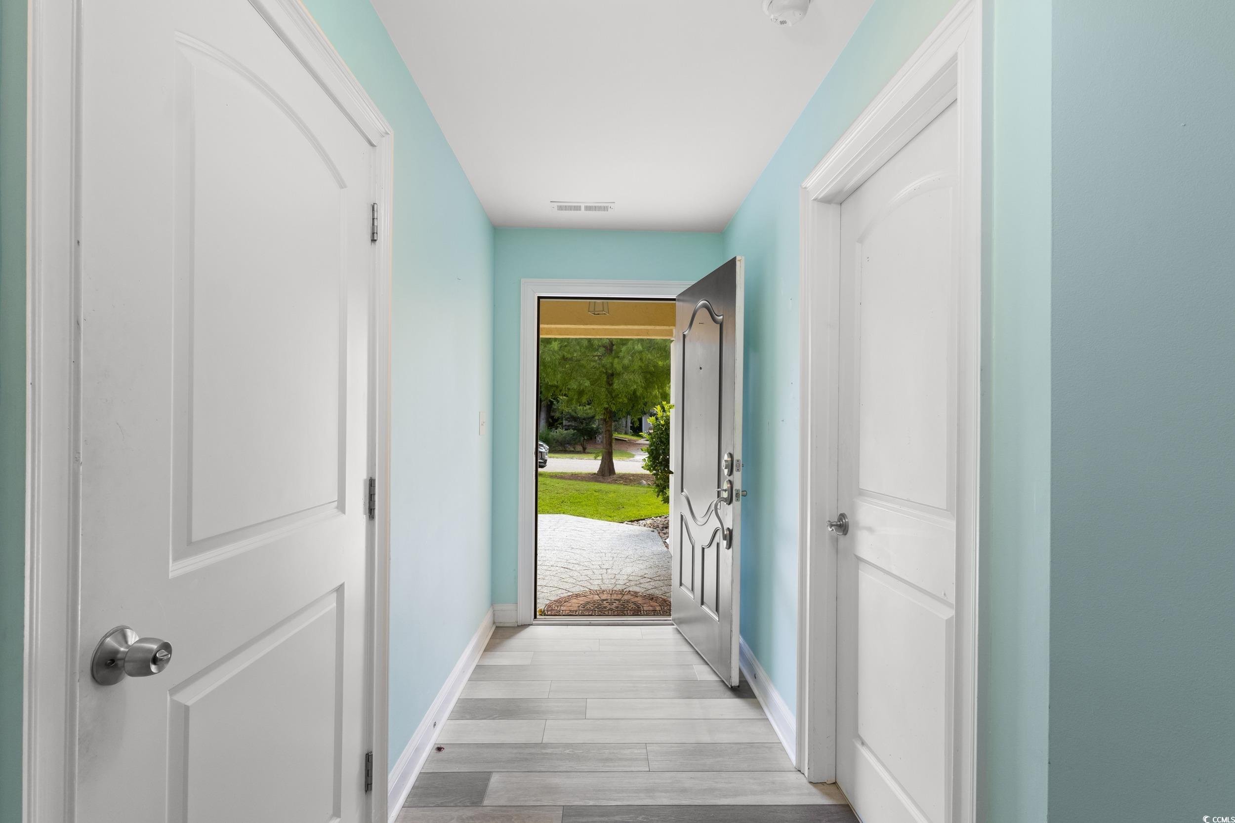 Image 3: Entryway with light wood-style floors and baseboar
