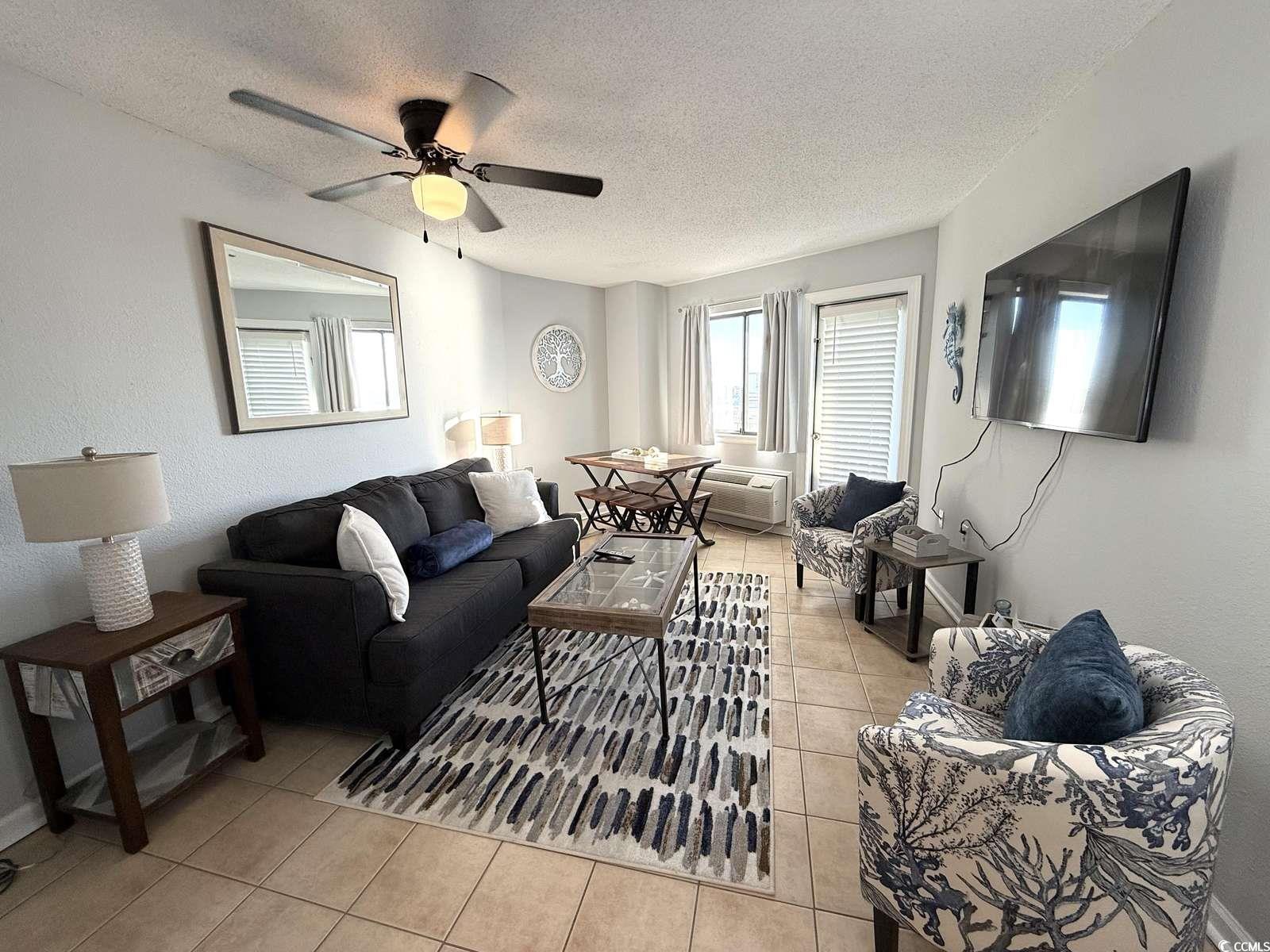 Image 4: Living area with light tile patterned flooring, a Image 4: Living area with light tile patterned flooring, a