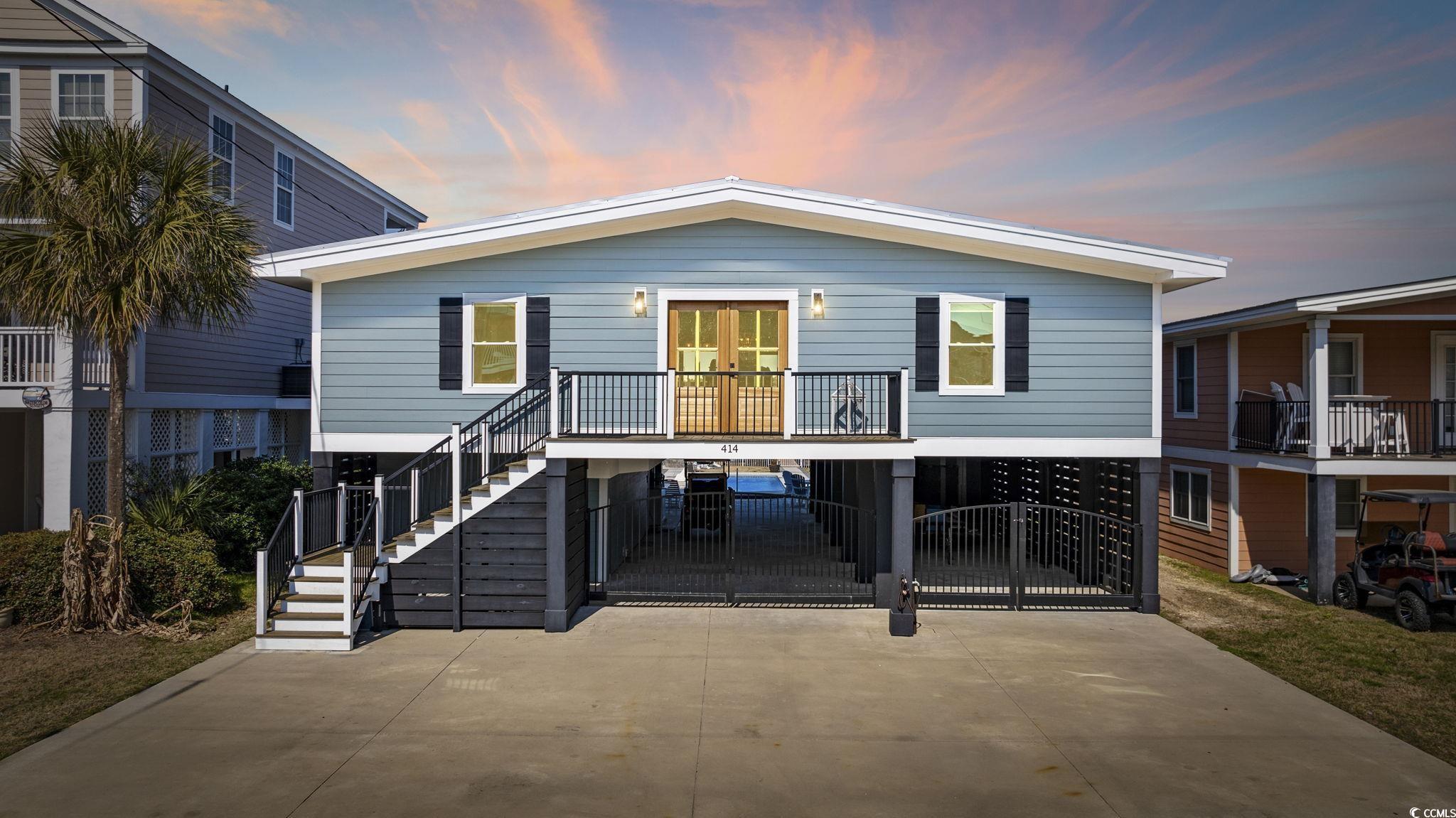 Image 2: Back of house at dusk with a carport, concrete dri