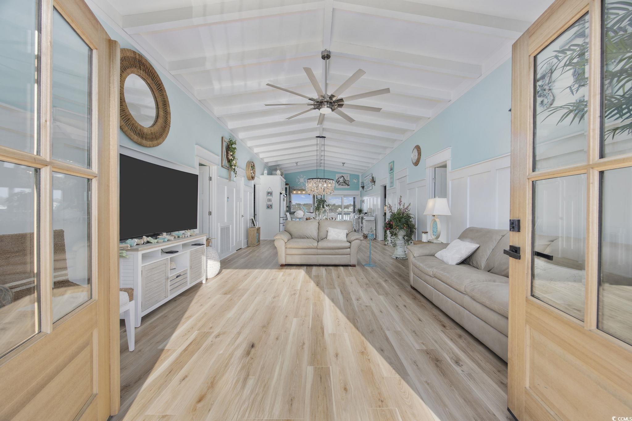 Image 3: Living area with light wood-style floors, a ceilin