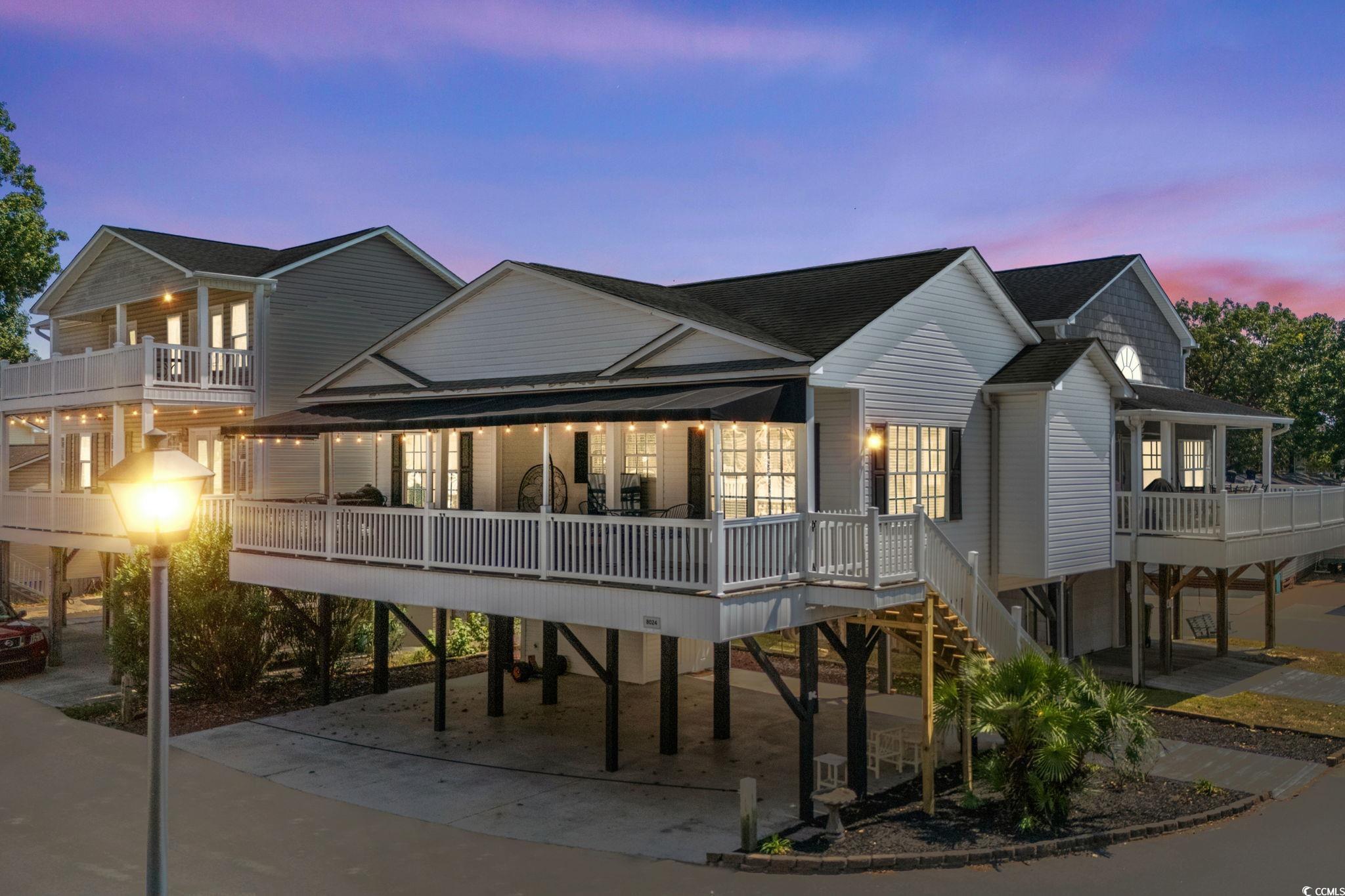Image 1: Coastal inspired home featuring a carport, a woode Image 1: Coastal inspired home featuring a carport, a woode
