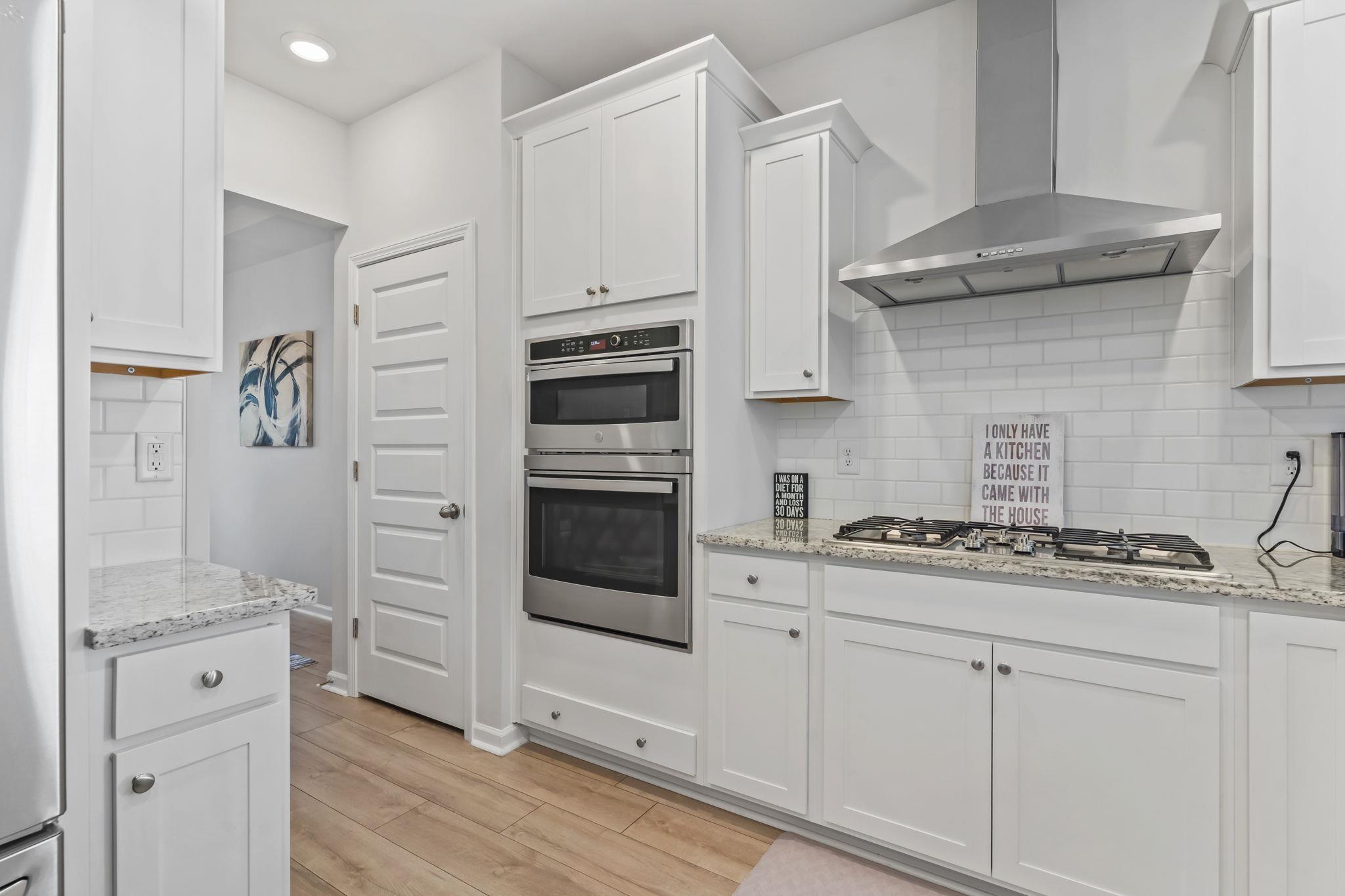Image 4: Kitchen with white cabinets, wall chimney exhaust Image 4: Kitchen with white cabinets, wall chimney exhaust
