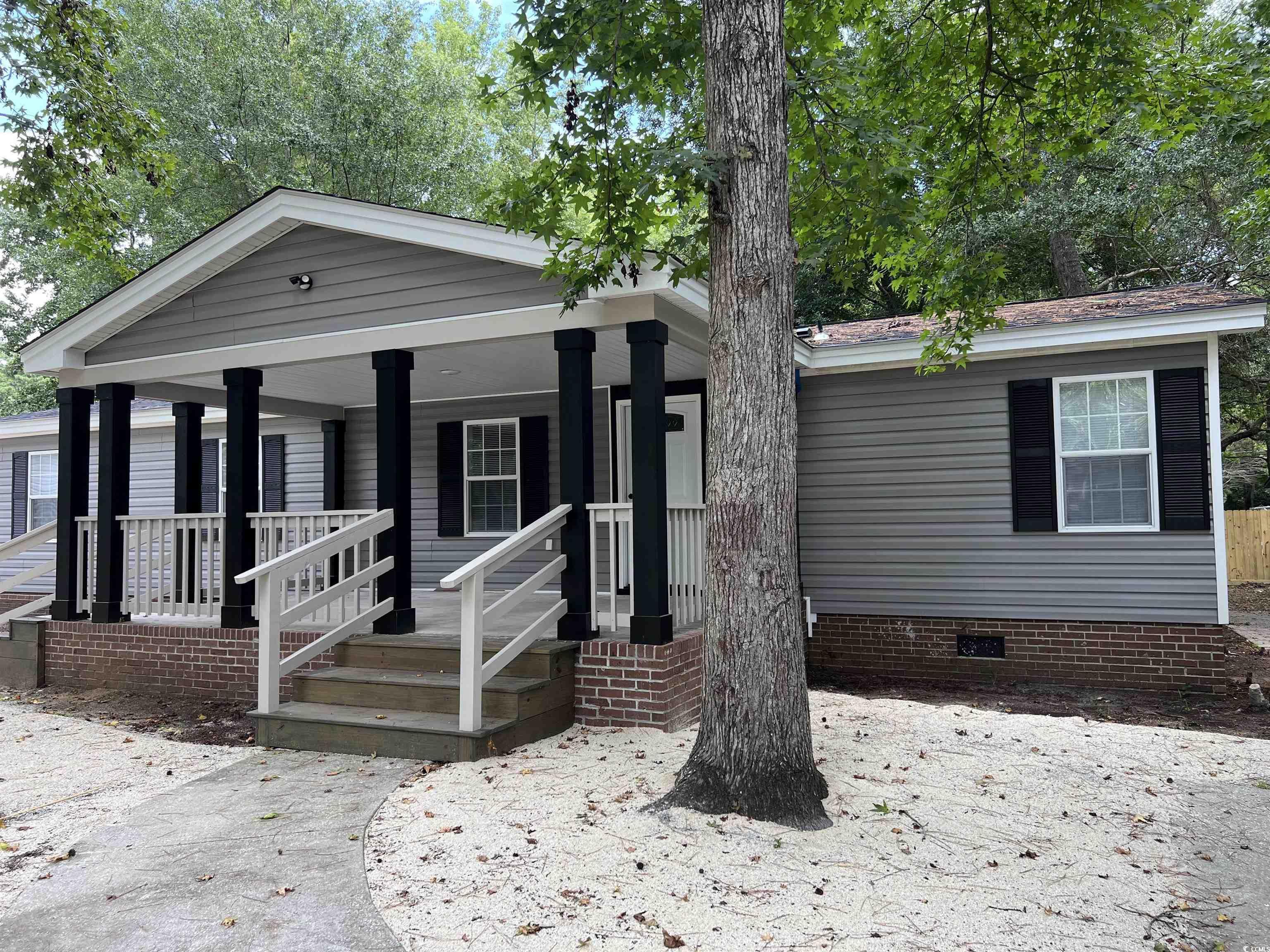 Image 2: View of front of home with a porch and crawl space