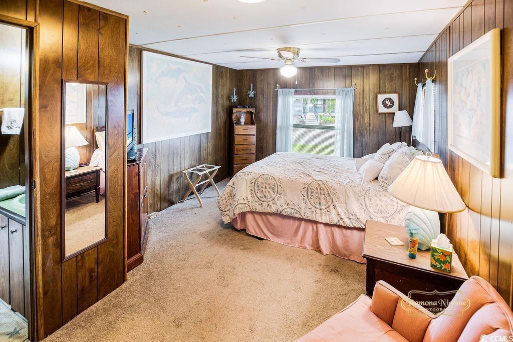 Image 2: Carpeted bedroom featuring wood walls and a ceilin Image 2: Carpeted bedroom featuring wood walls and a ceilin