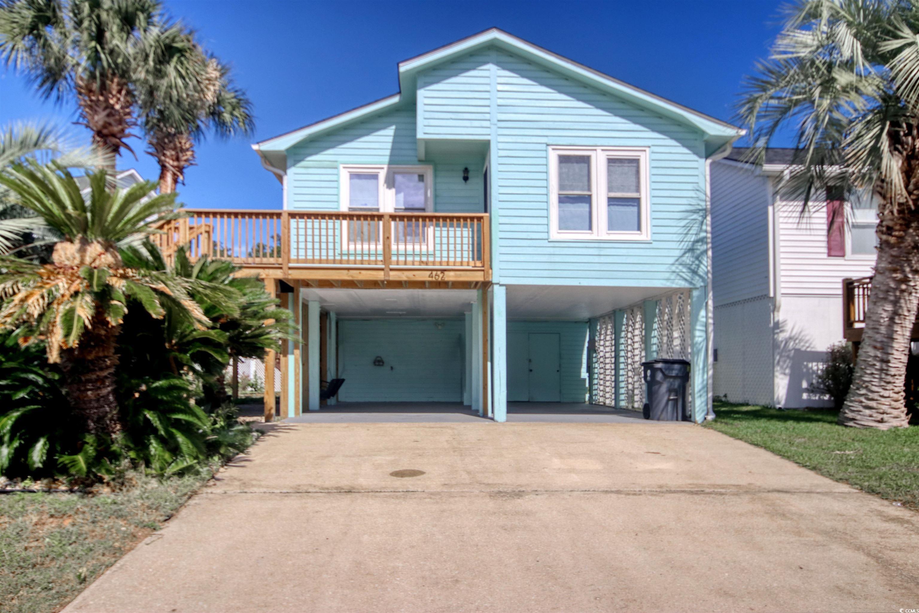 Image 1: Coastal inspired home with a carport and driveway