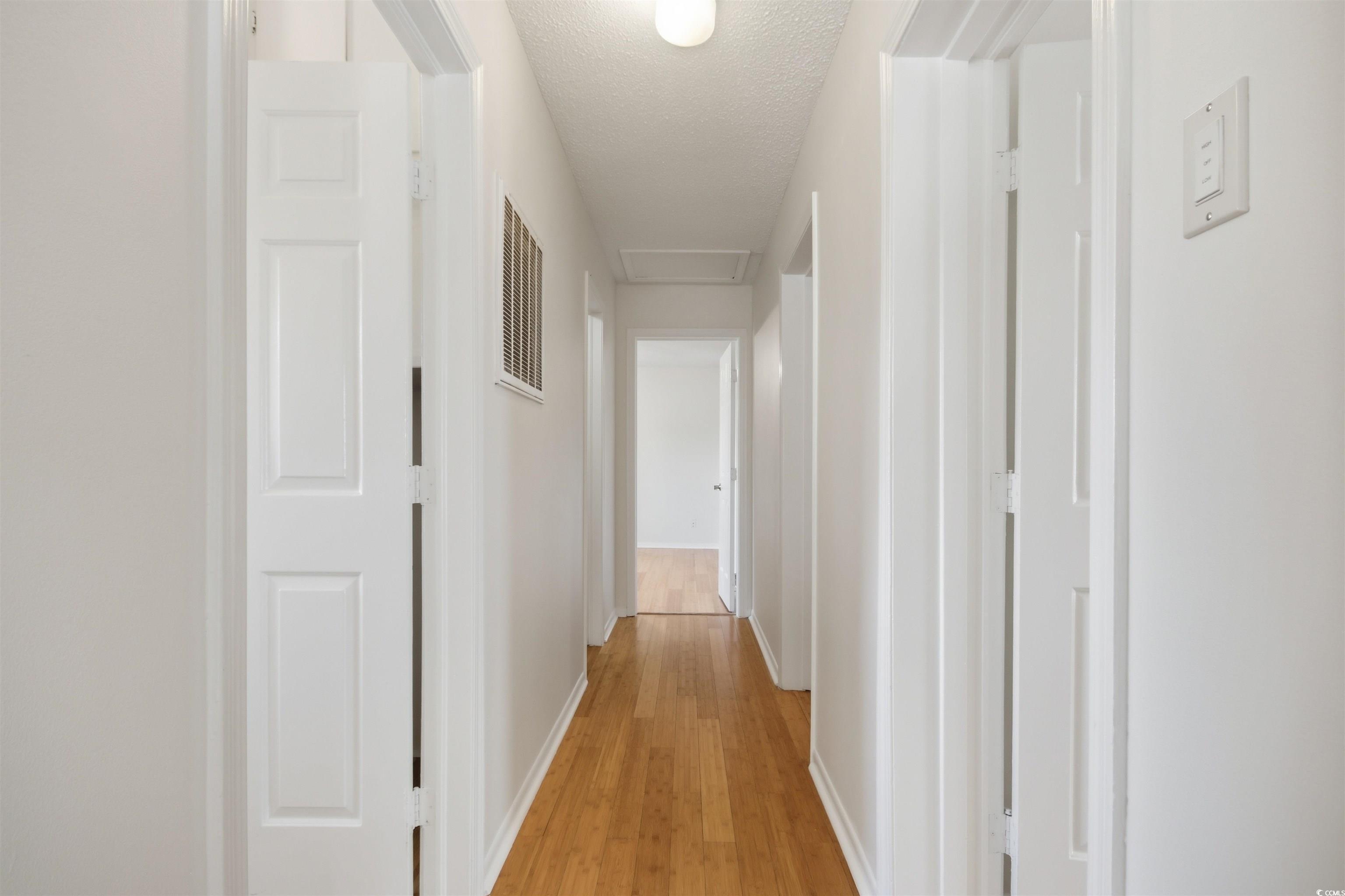 Image 4: Hallway with light wood-style flooring, attic acce
