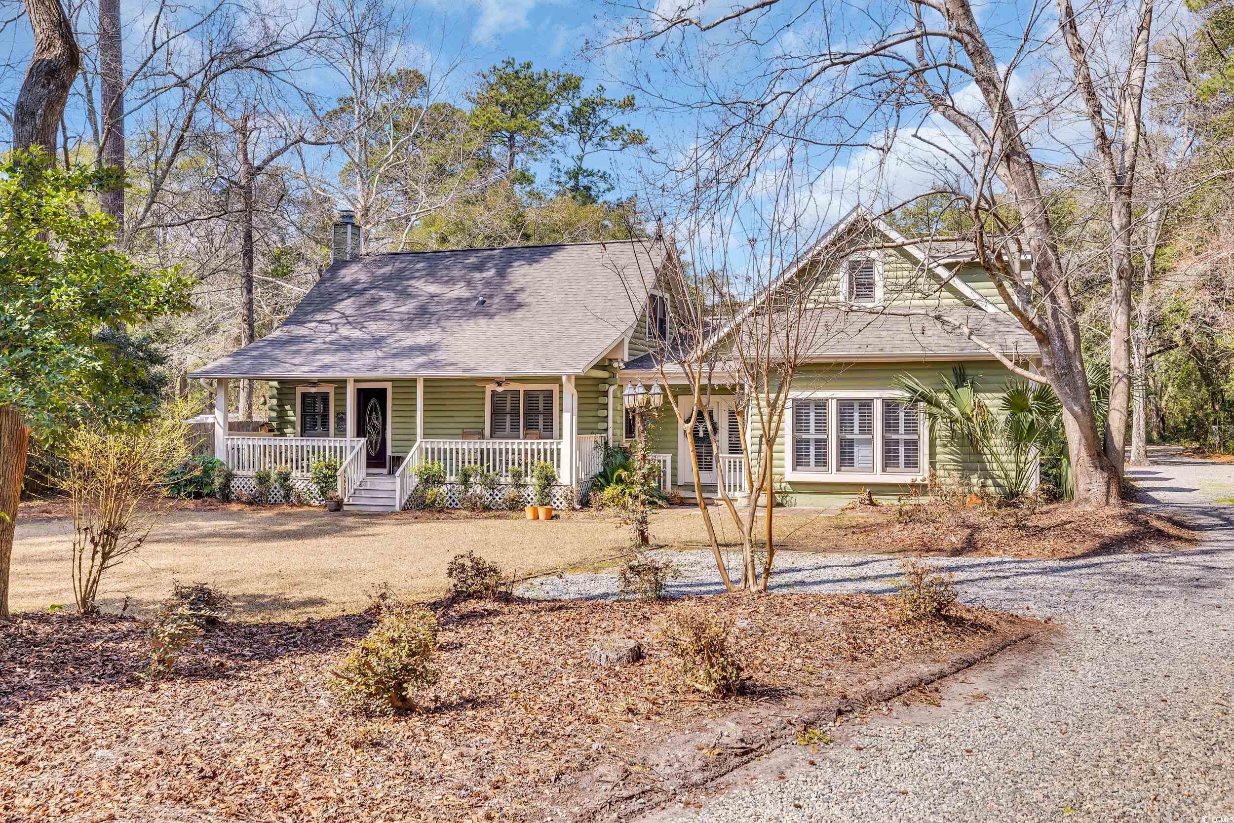 Image 1: View of front facade with covered porch, driveway,