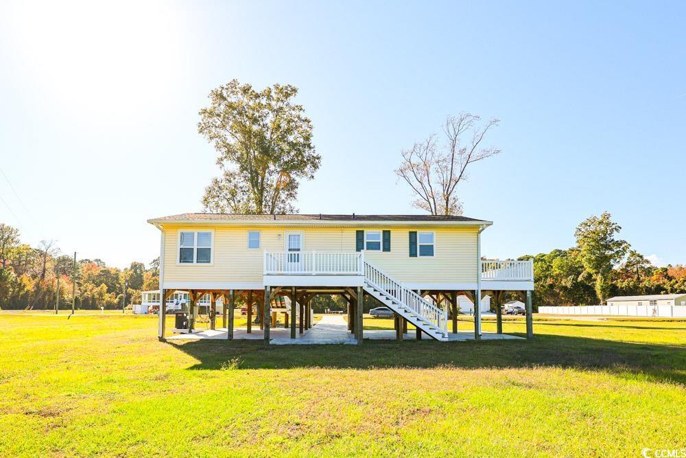 Image 2: Rear view of house featuring a yard, stairway, a w Image 2: Rear view of house featuring a yard, stairway, a w