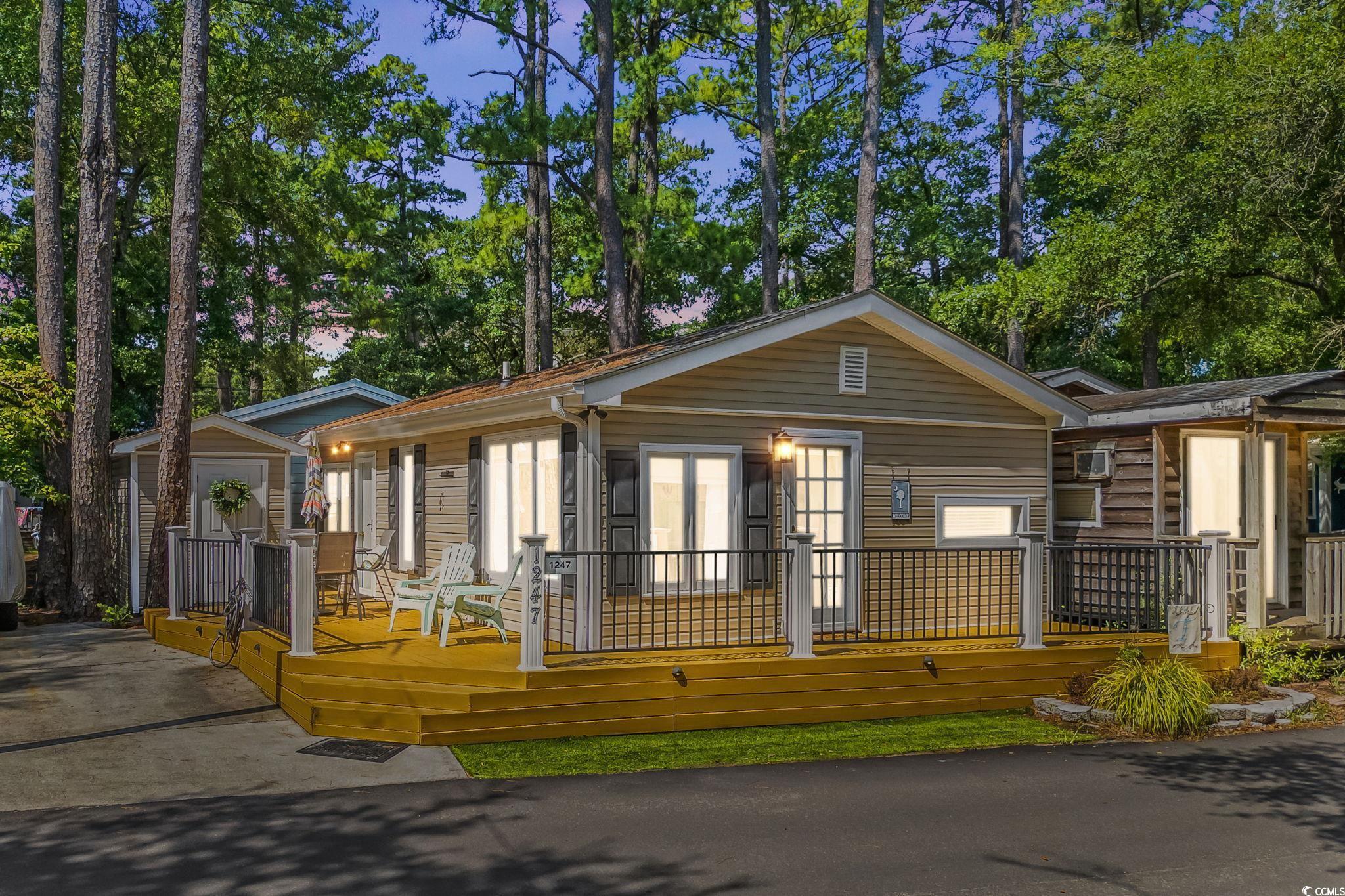 Image 2: View of front facade featuring a wooden deck and v Image 2: View of front facade featuring a wooden deck and v