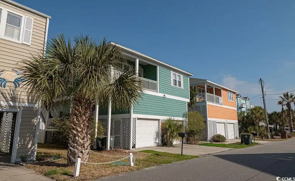Image 1: Beach home with a balcony, concrete driveway, and Image 1: Beach home with a balcony, concrete driveway, and