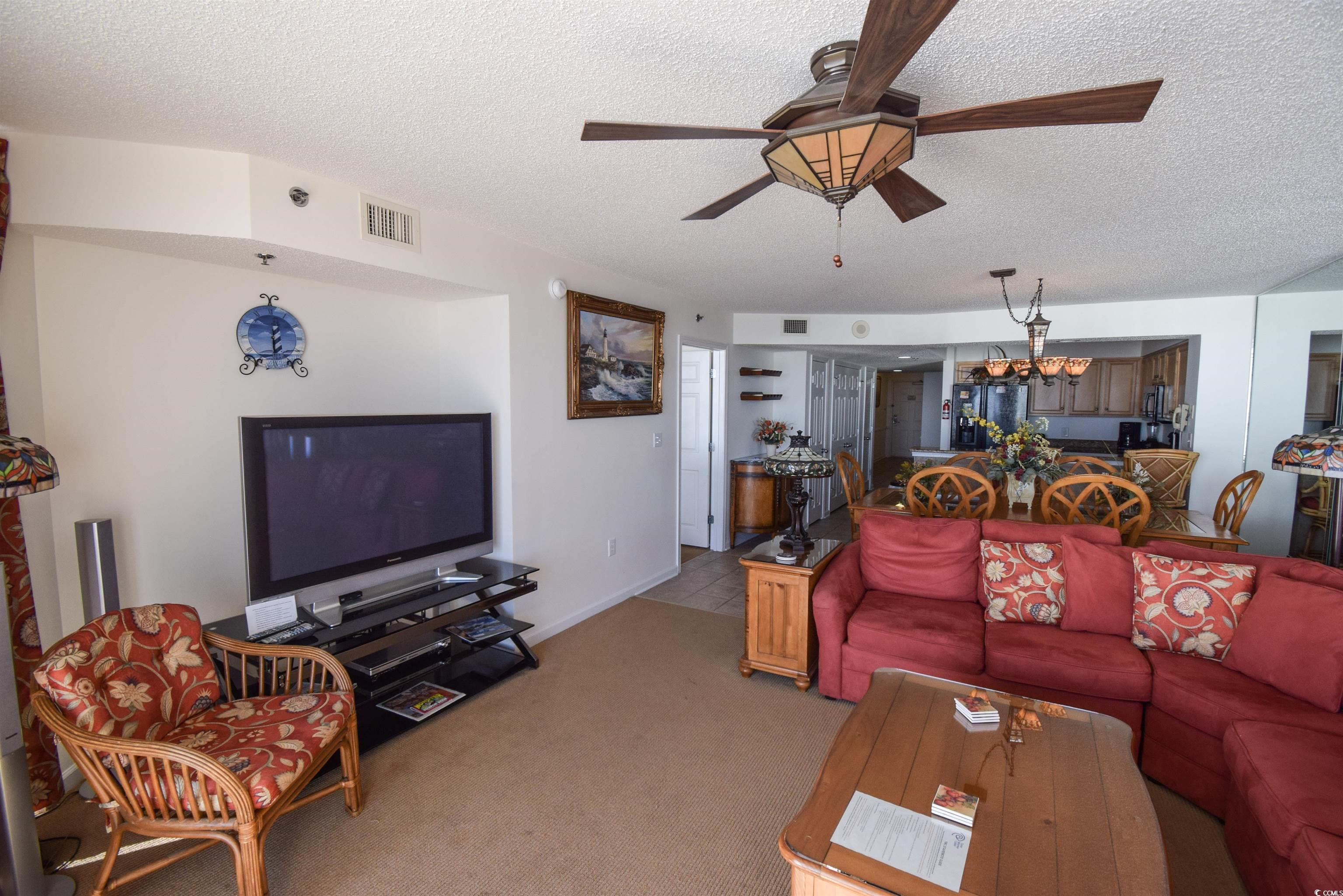 Image 2: Living room with ceiling fan with notable chandeli Image 2: Living room with ceiling fan with notable chandeli