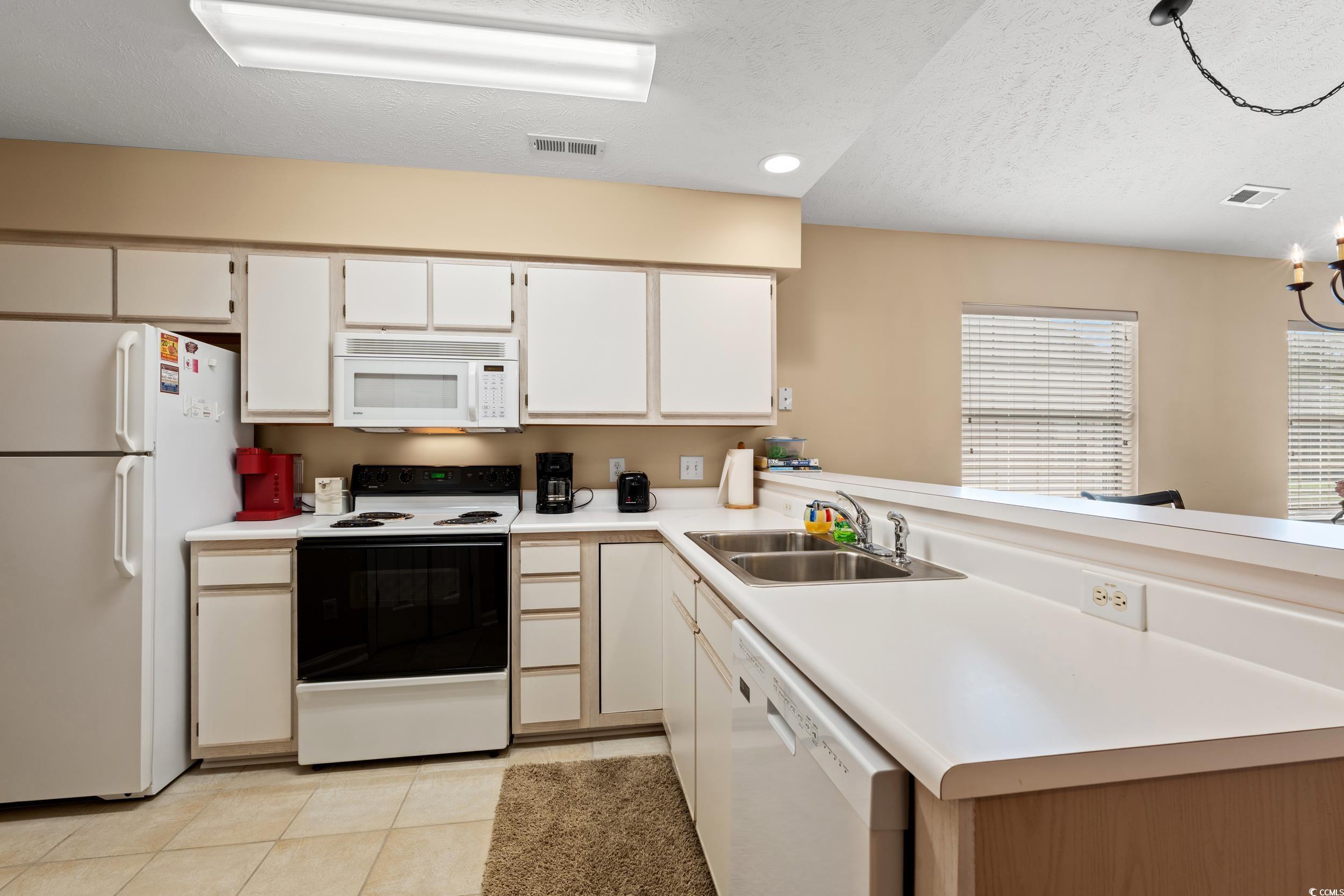 Image 3: Kitchen featuring white appliances, light tile pat Image 3: Kitchen featuring white appliances, light tile pat