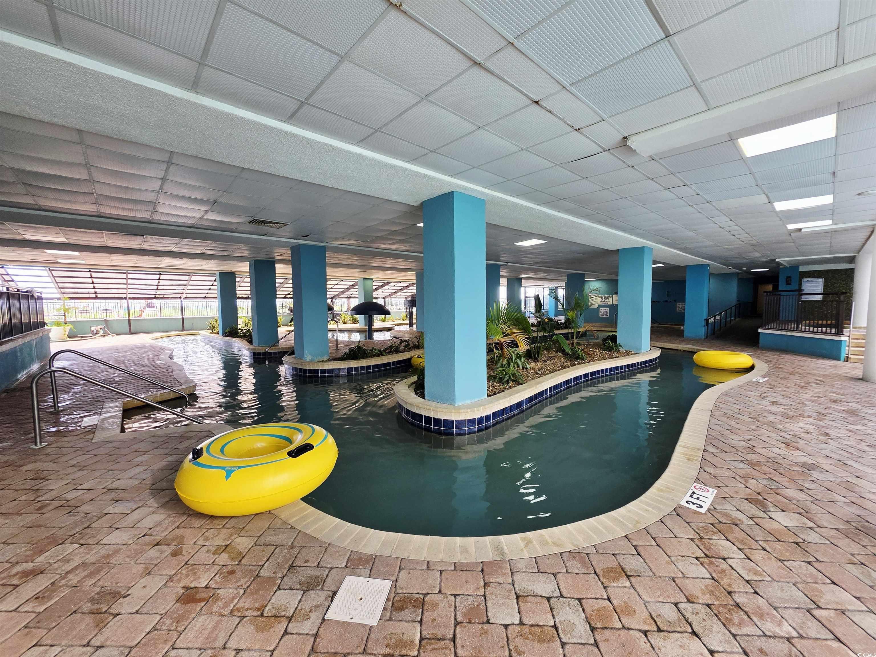 Image 4: Indoor pool with a patio area