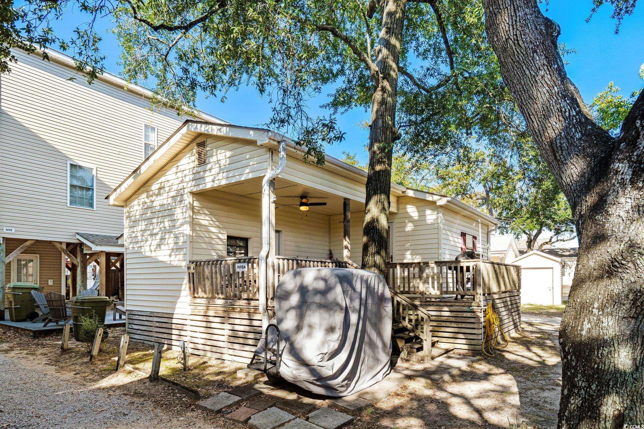 Image 3: View of front facade featuring a wooden deck, an o Image 3: View of front facade featuring a wooden deck, an o