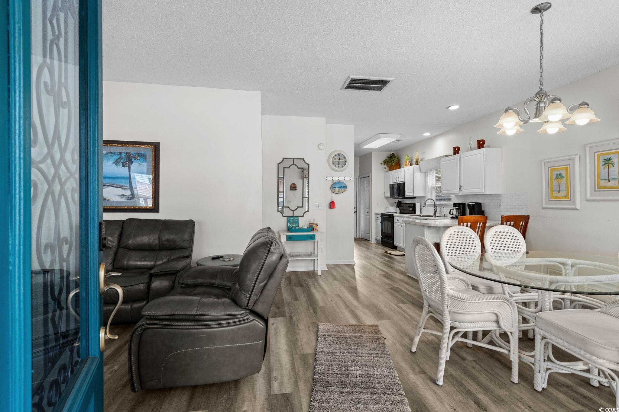 Image 3: Dining area with light wood-style floors, a chande Image 3: Dining area with light wood-style floors, a chande