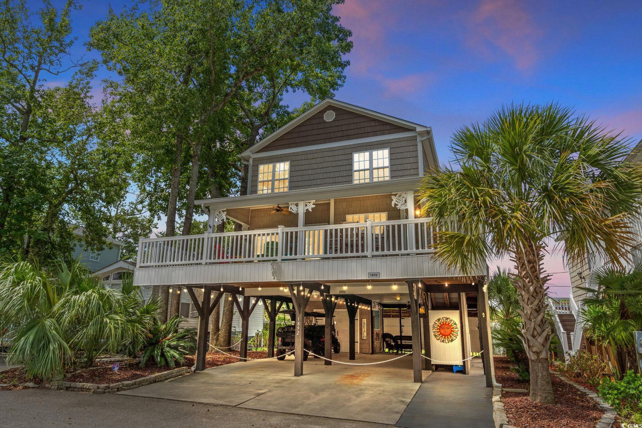 Image 1: Rear view of property featuring a carport and driv