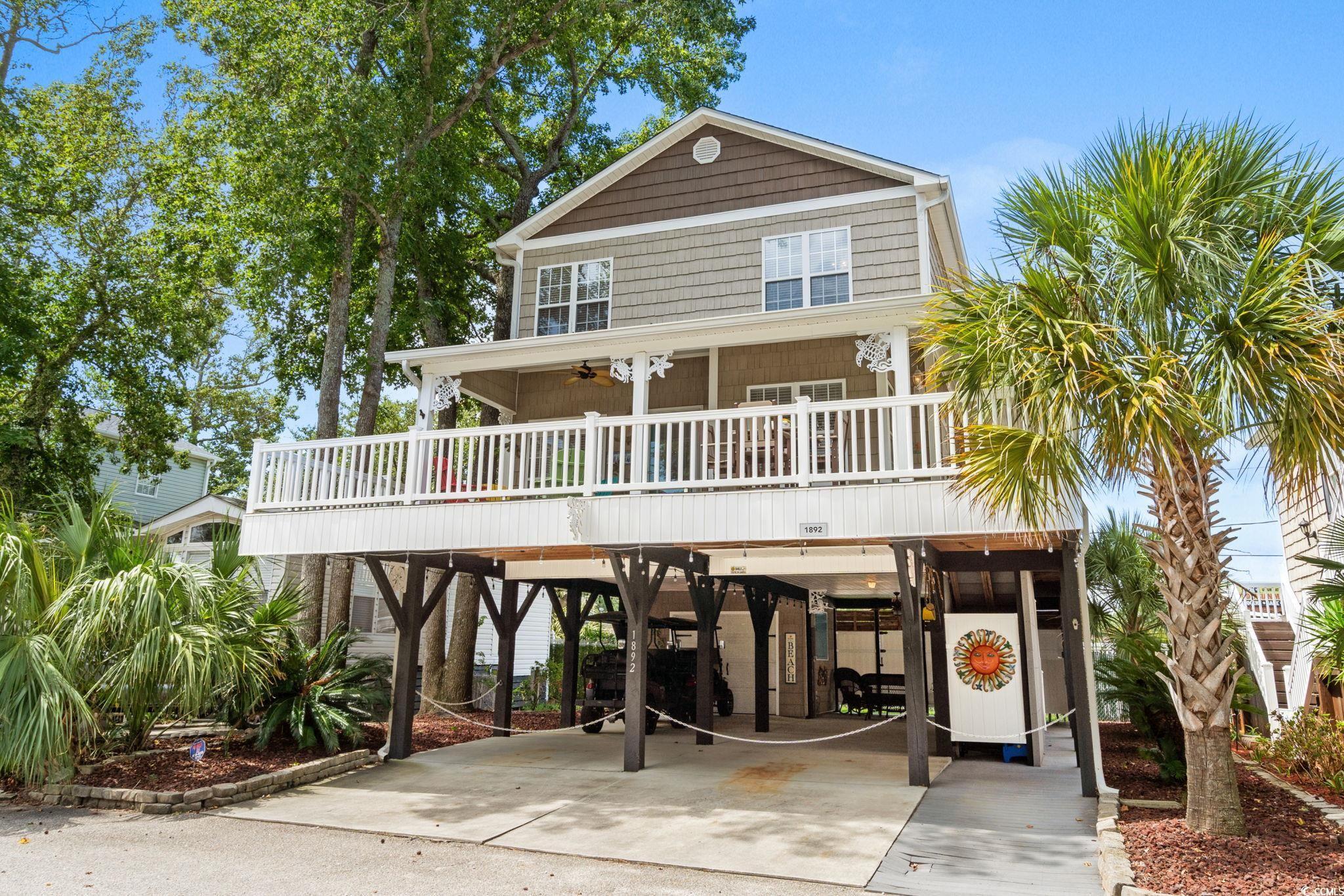 Image 2: Raised beach house with a carport, a ceiling fan,