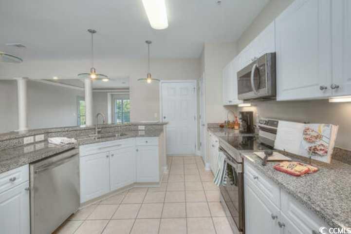 Image 4: Kitchen with white cabinetry, stainless steel appl Image 4: Kitchen with white cabinetry, stainless steel appl
