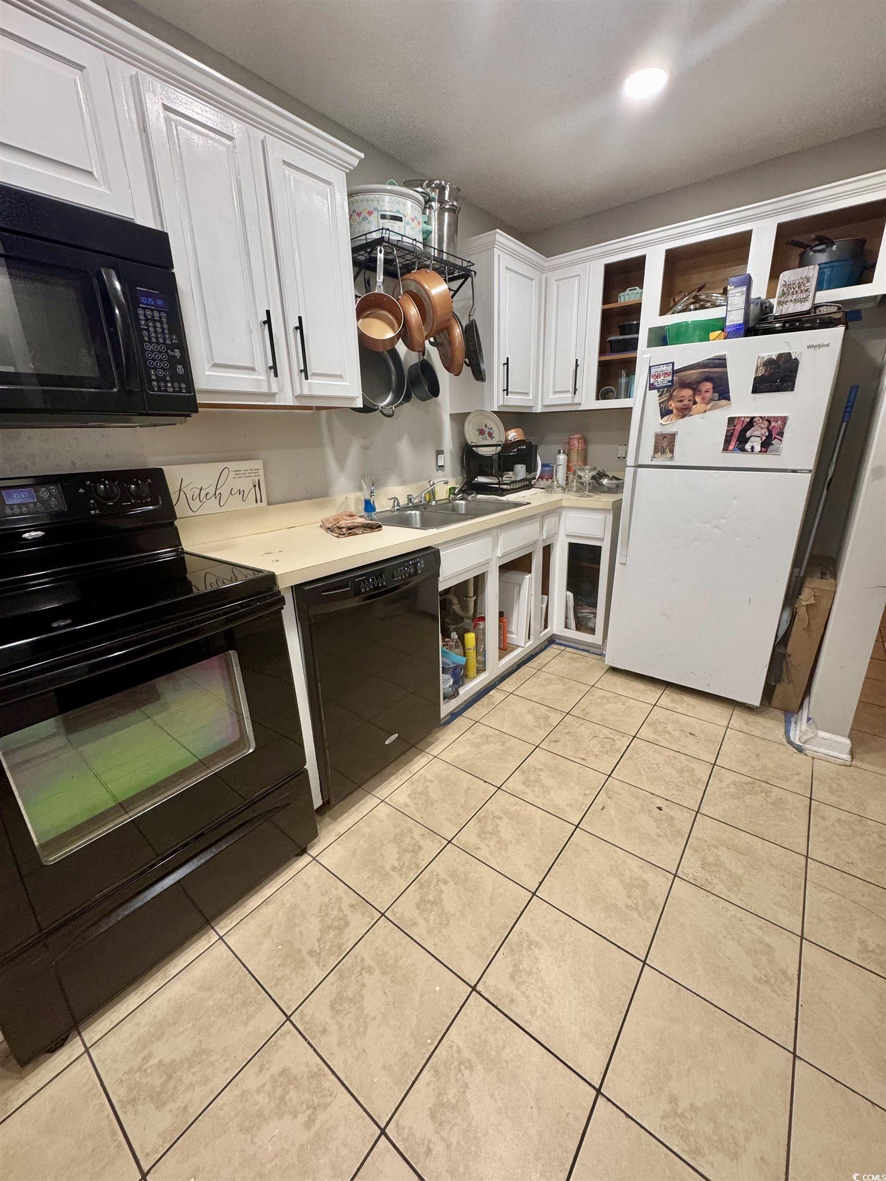 Image 2: Kitchen with black appliances, white cabinets, lig Image 2: Kitchen with black appliances, white cabinets, lig