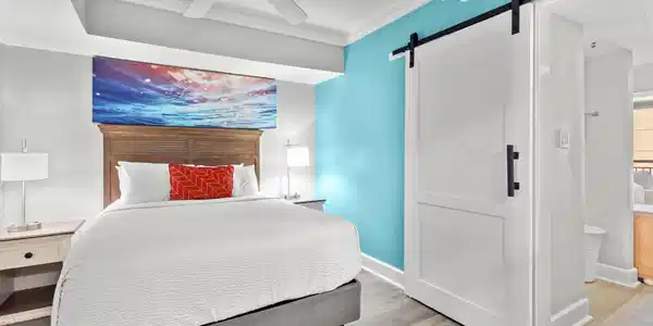 Image 3: Bedroom featuring a barn door, ornamental molding,
