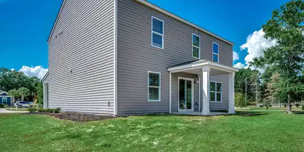 Image 2: Back of property featuring a patio area and a lawn