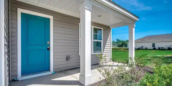 Image 4: Doorway to property with a porch and a lawn