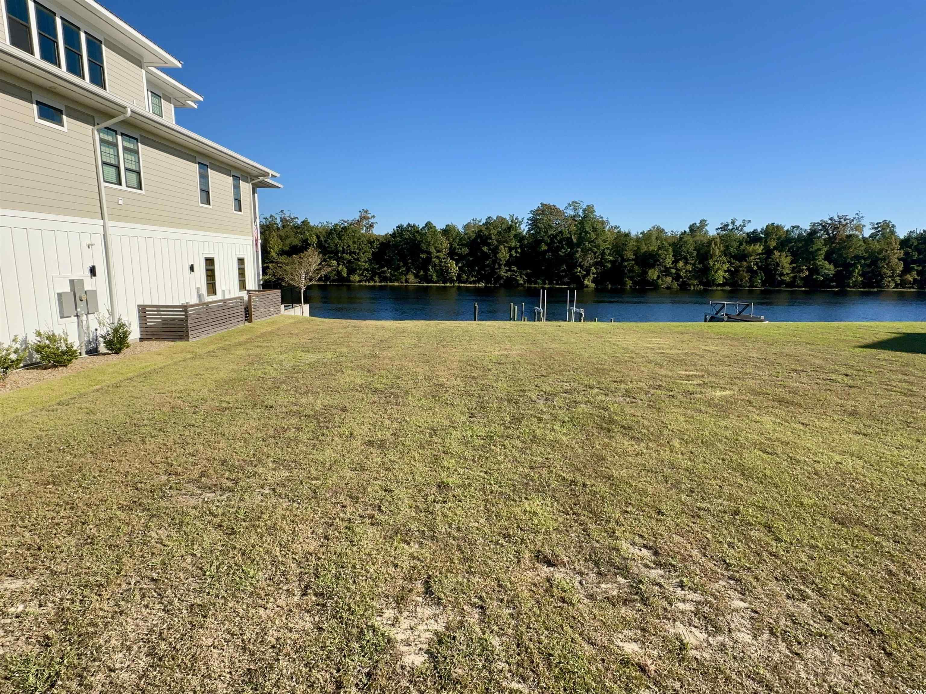 Image 1: View of grassy yard with a water view