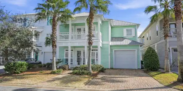 Image 3: Coastal minty green house with palm tree