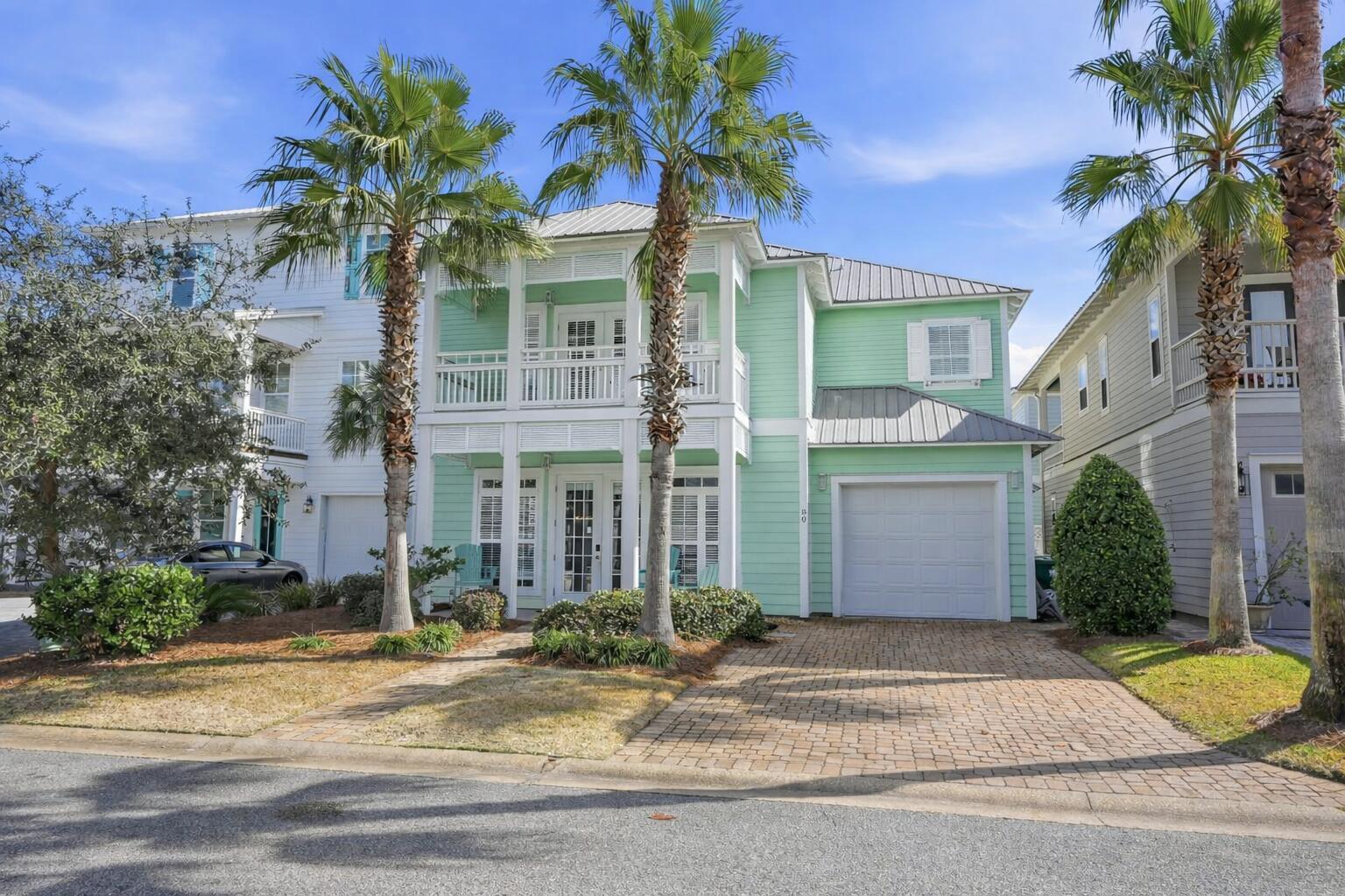 Image 2: Coastal minty green house with palm tree