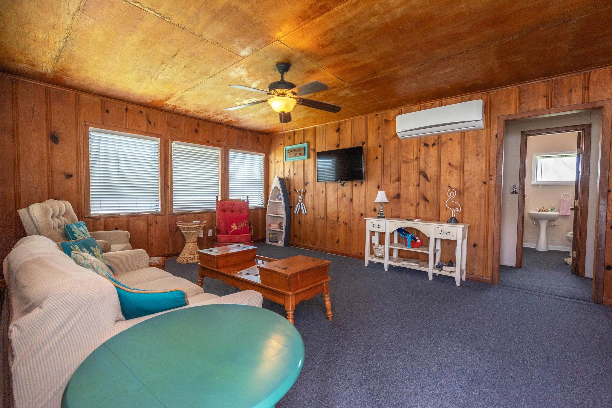 Image 3: This cozy living room features warm wood paneling,
