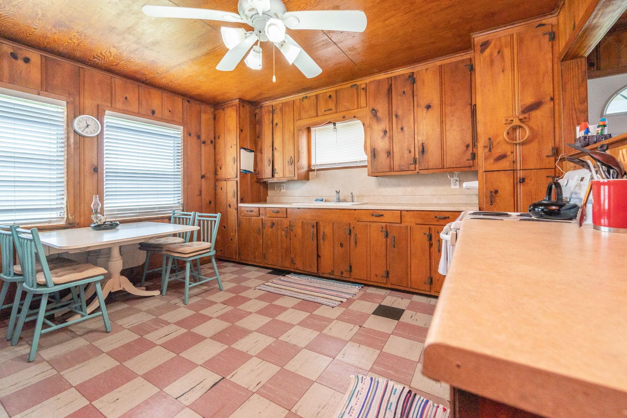 Image 4: A cozy kitchen featuring warm wood paneling and ca