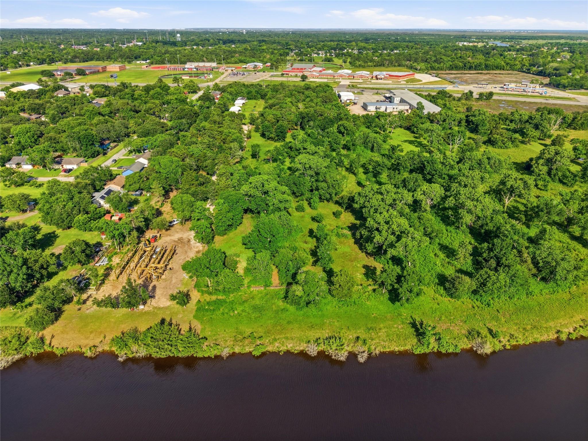 Image 2: Expansive aerial view of a lush, green property wi