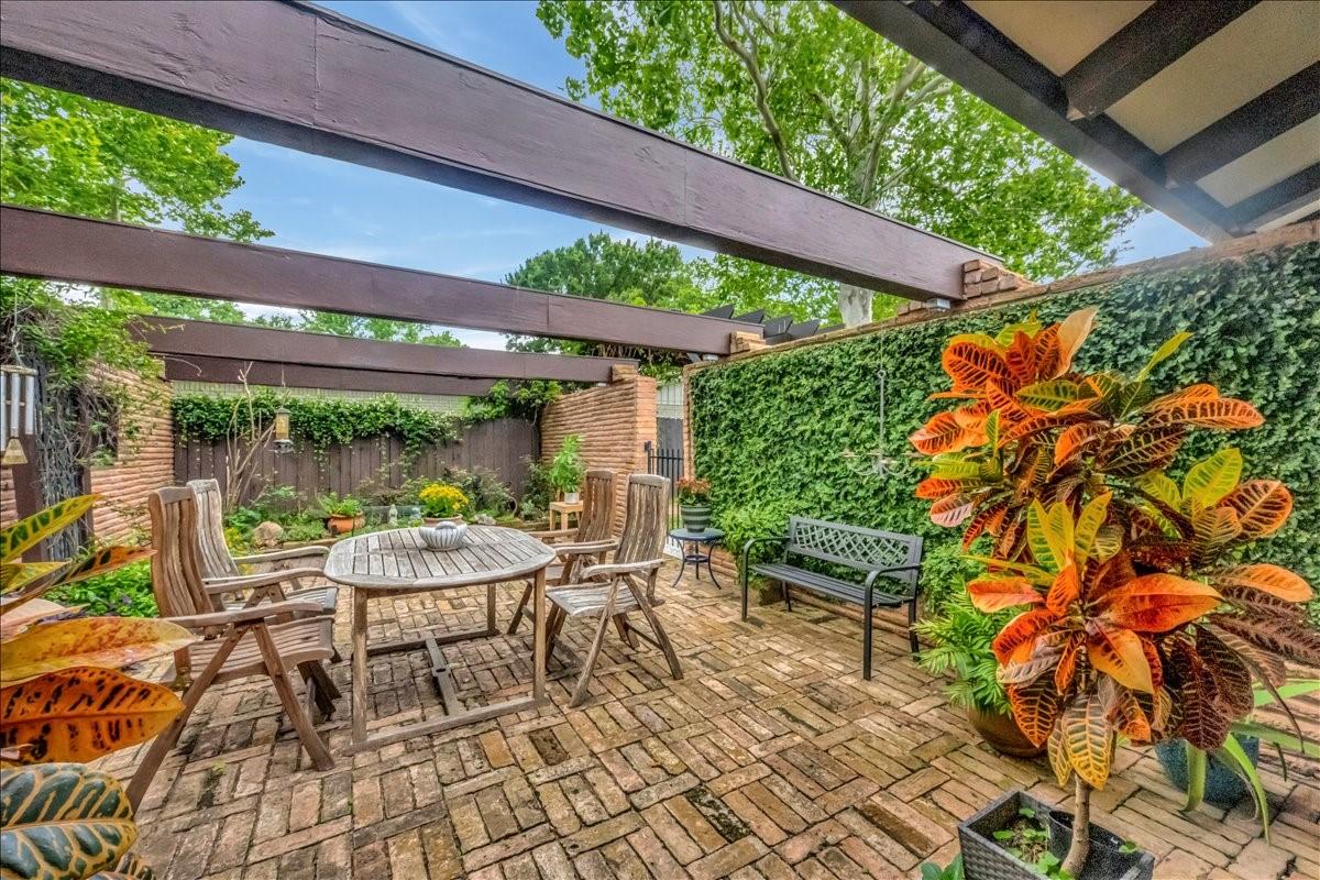 Image 3: Charming outdoor patio with rustic brick flooring,