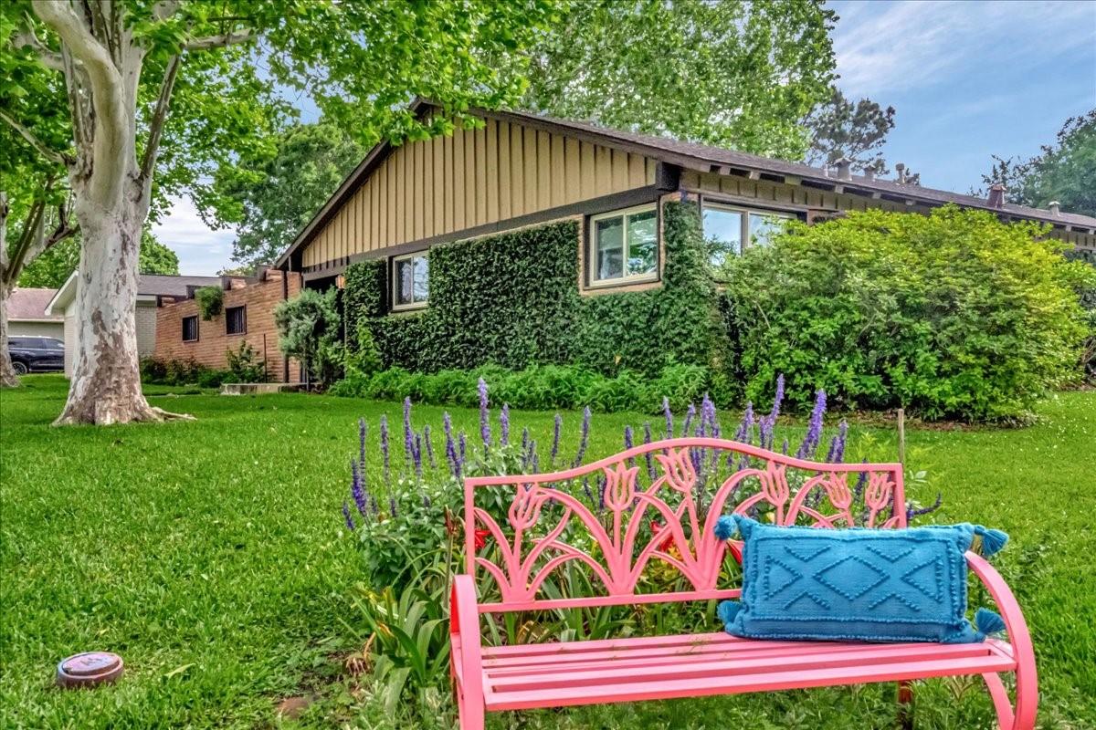 Image 4: Charming single-story home with lush greenery and