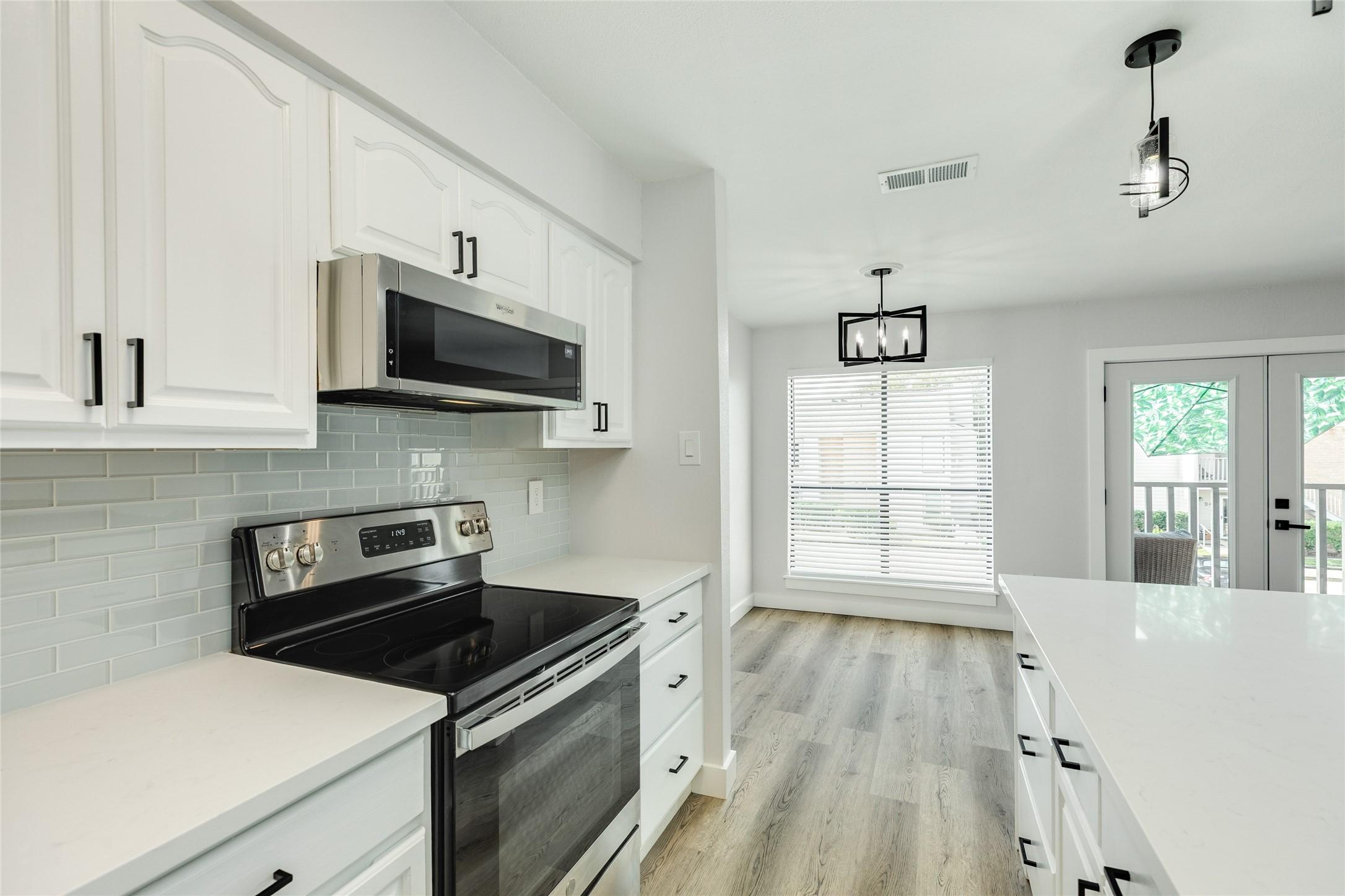 Image 3: Kitchen opens to dining, living and balcony.  Ligh