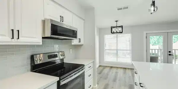 Image 3: Kitchen opens to dining, living and balcony.  Ligh