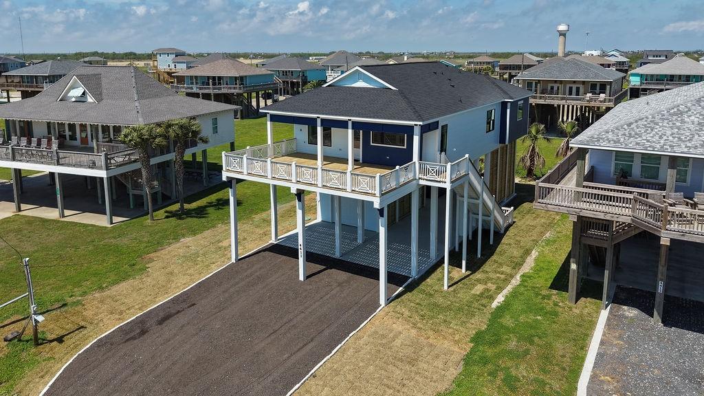 Image 4: Elevated coastal home with a spacious deck, surrou