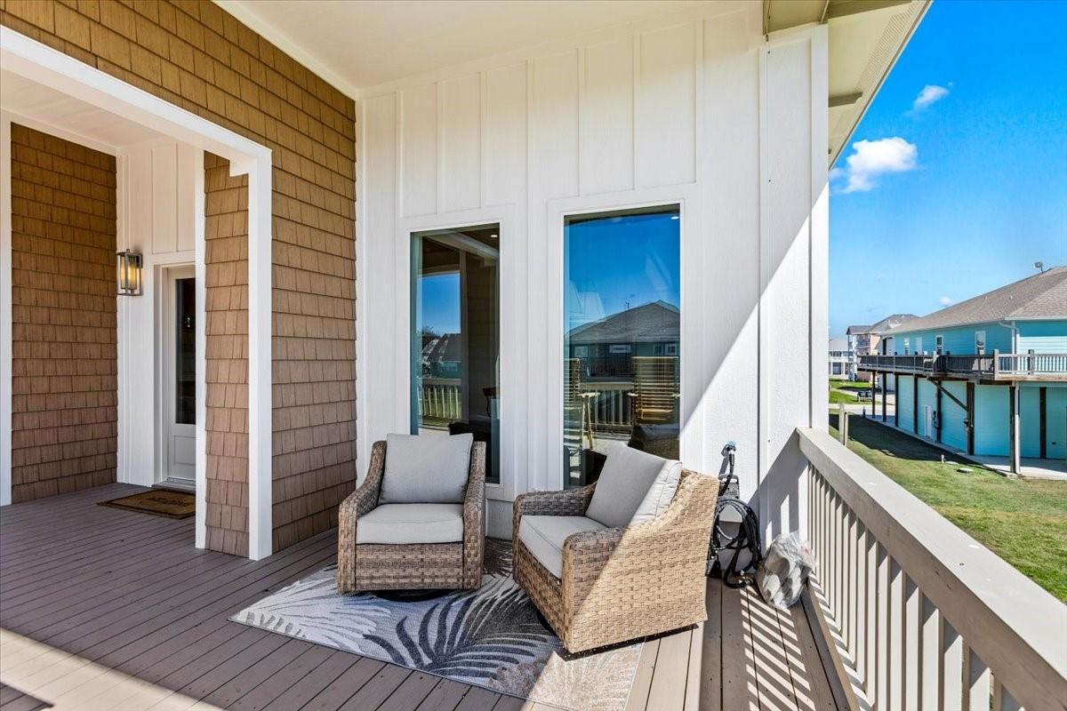 Image 2: Charming porch with cozy seating and a view of nei