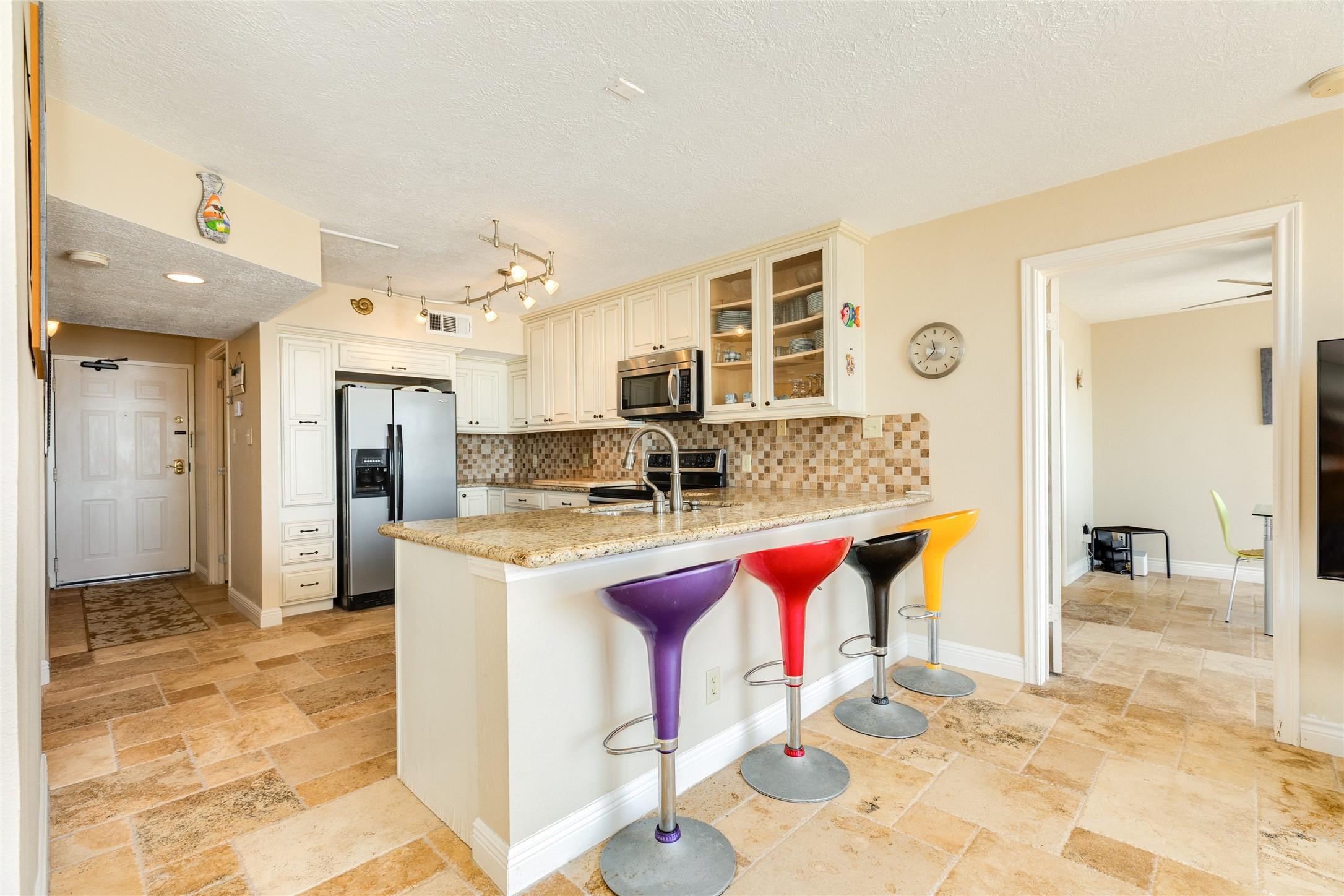 Image 4: Large kitchen with colorful barstools to set the b