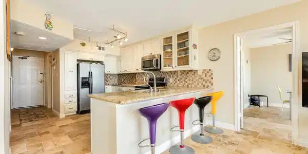 Image 4: Large kitchen with colorful barstools to set the b