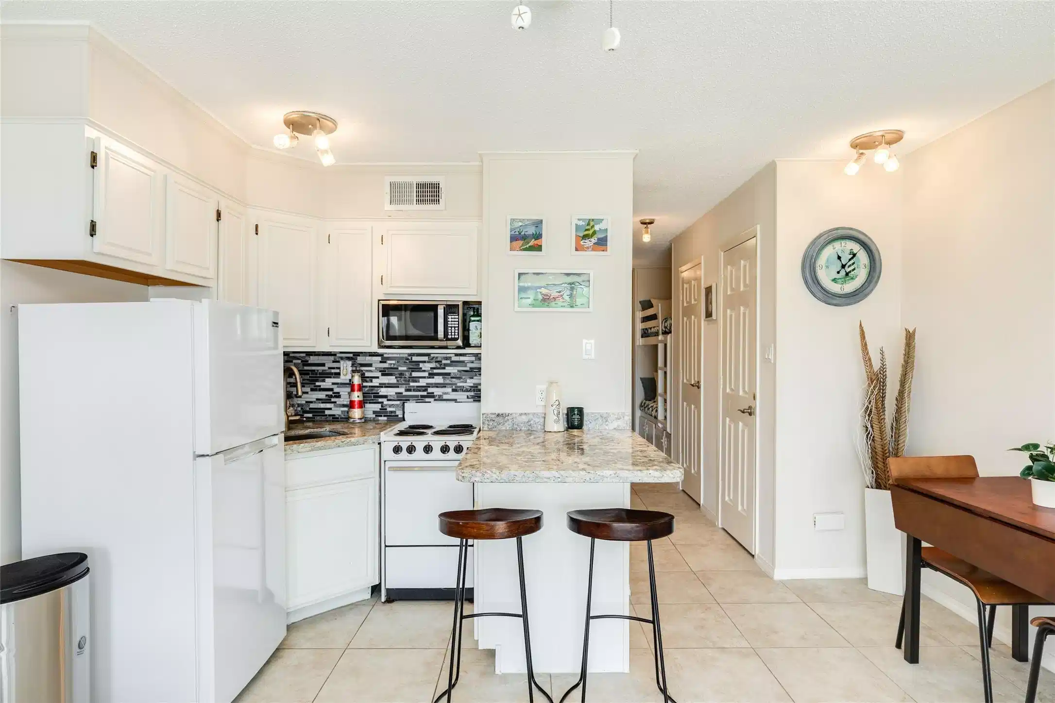 Image 1: Small but efficient kitchen includes refrigerator,