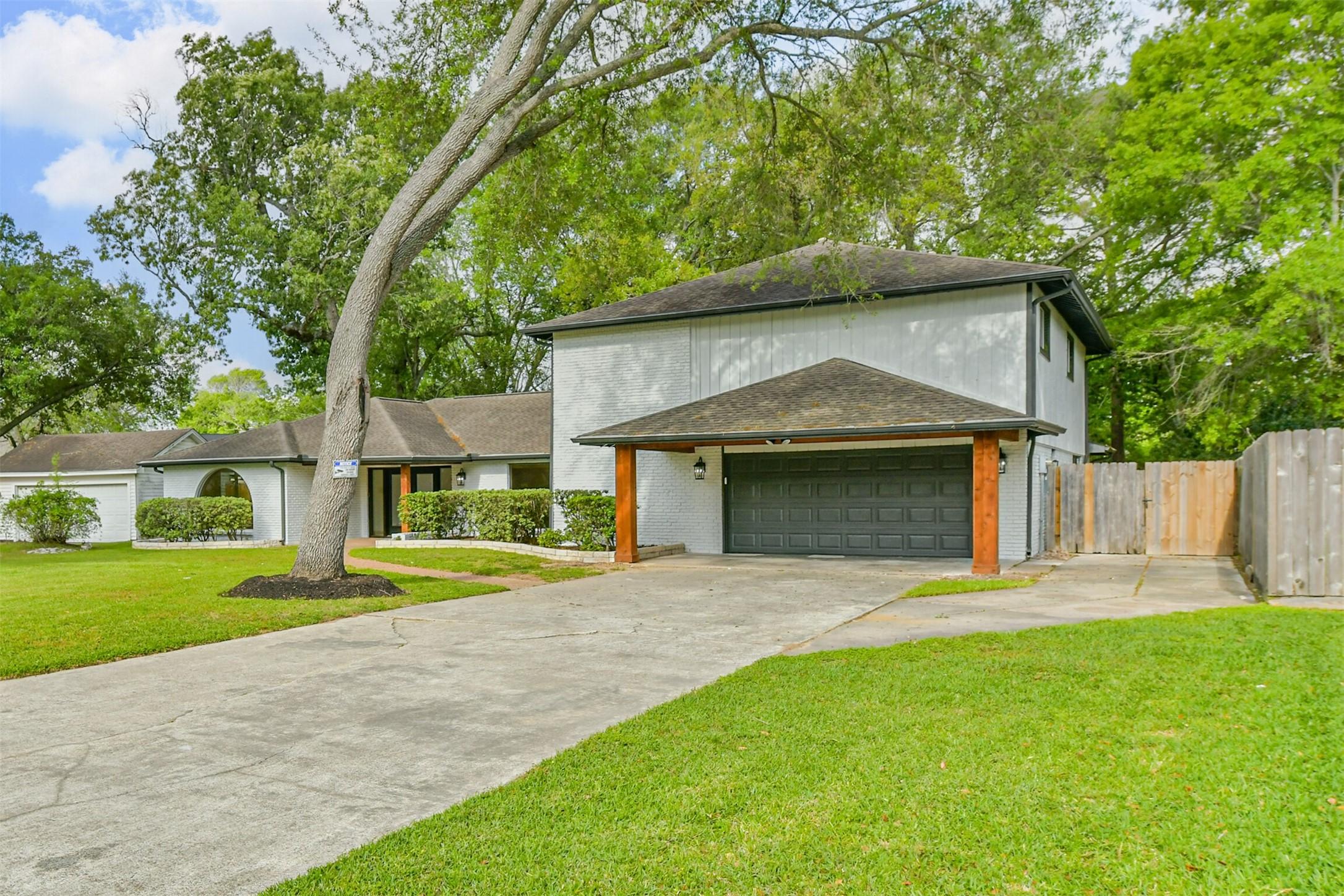 Image 3: Long, double-wide driveway with a carport and 2-ca