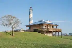 Image 2: The photo shows a light house with a large deck, s